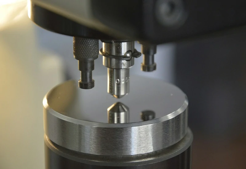Hardness tester indenter measuring a polished metal sample